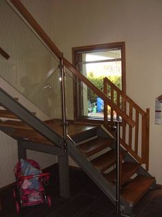 metallirunkoinen portaikko puisin askelmin portilla ja kaiteella