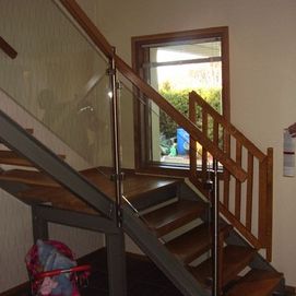 metallirunkoinen portaikko puisin askelmin portilla ja kaiteella